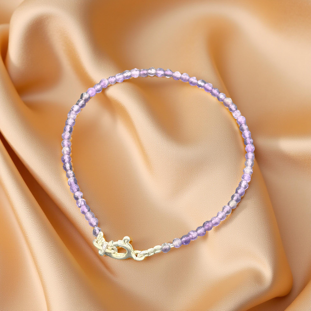 Amethyst Armband auf glänzendem, goldenem Seidenstoff