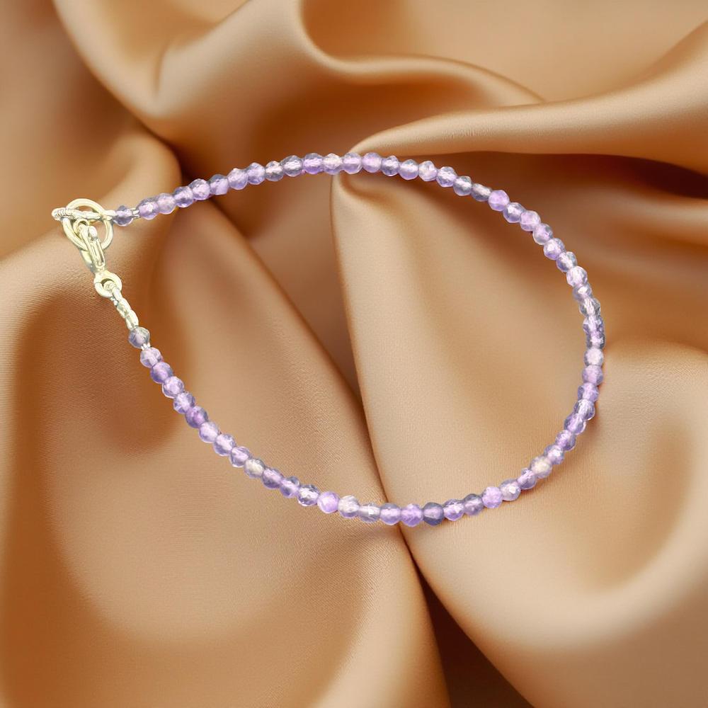Amethyst Armband auf glänzendem, goldenem Seidenstoff