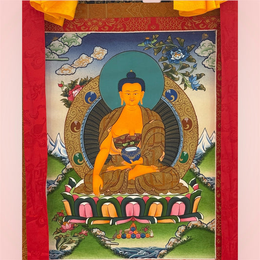 Buddha Shakyamuni Thangka mit dunkler Brokateinfassung, roten Bändern und gelbem Stoffüberhang in Gesamtansicht