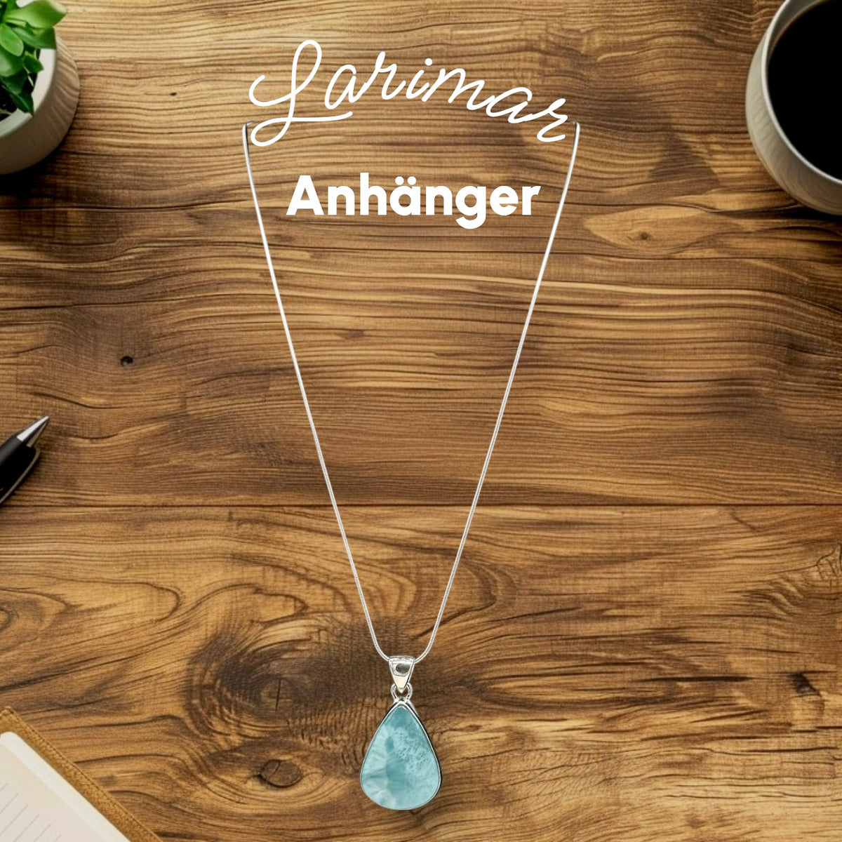 Larimar Anhänger mit einer Silber-Kette auf einem Tisch