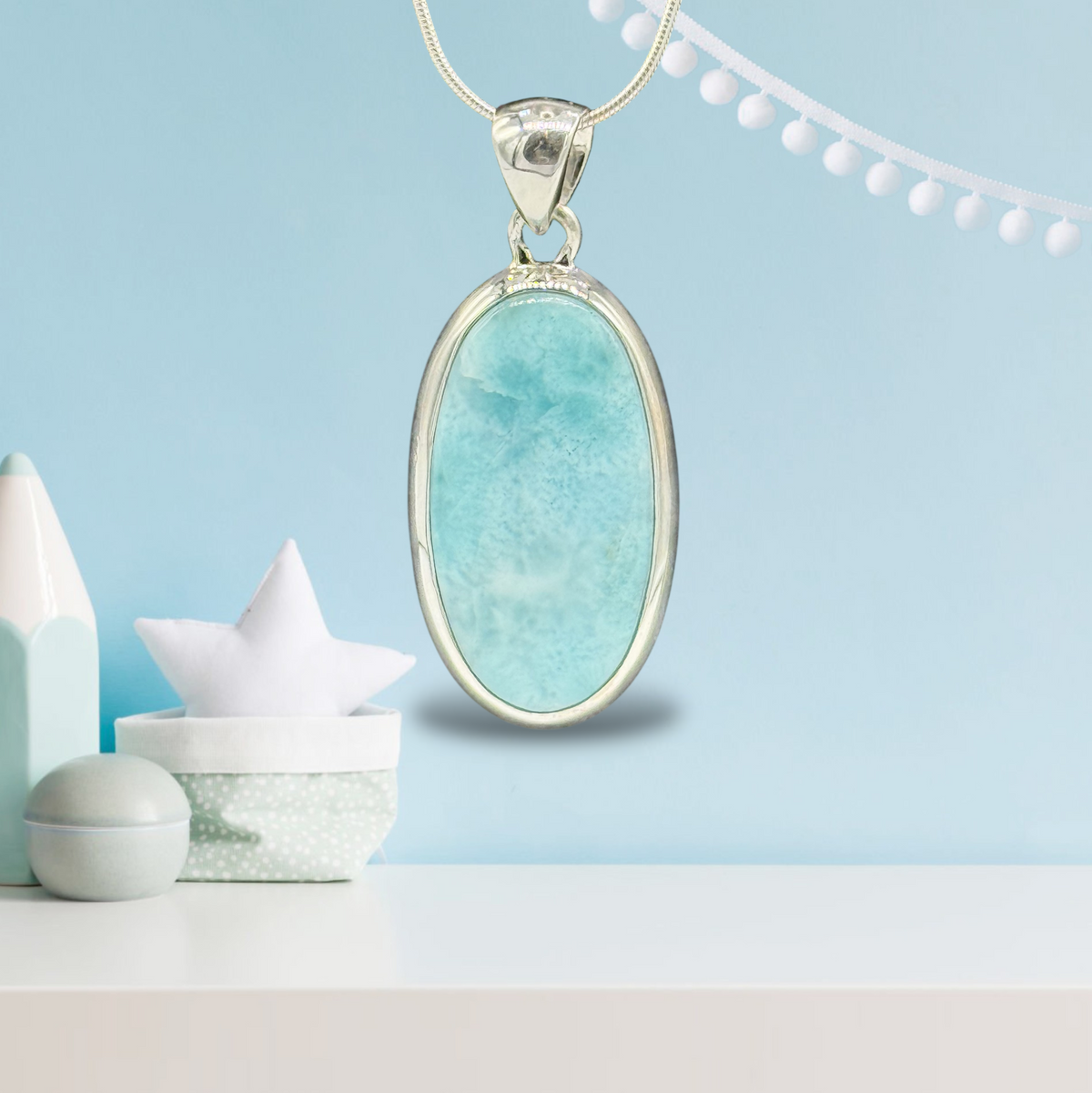 Zeigt Larimar Silber Anhänger mit einer Silber-Kette. Türkisblaues Hintergrund