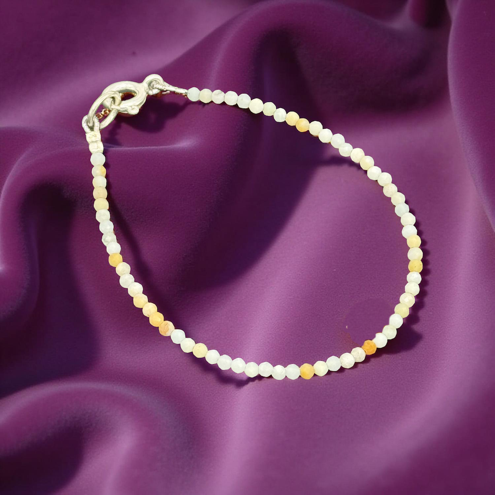 Mondstein Armband auf glänzendem, lila Seidenstoff