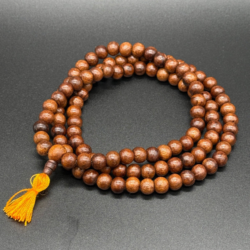 Gebetskette aus Rosenholz auf einem schwarzem Hintergrund