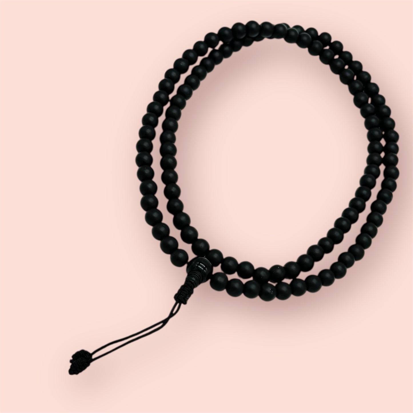 Shaligram 108 Mala, Schwarz auf einem beigen Hintergrund