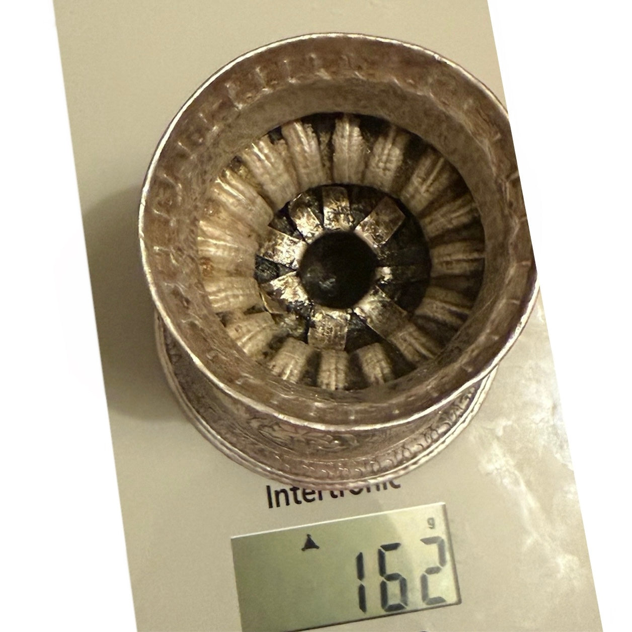 Auf dem Kopf stehendes Foto, das den unteren Innenbereich einer Butterlampe und das Gewicht 162 g zeigt.