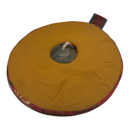 Buddhistische Zimbeln mit traditionellem Kissen dazwischen