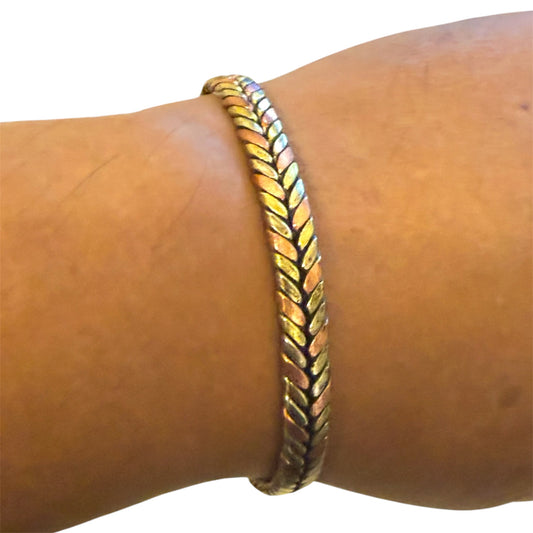 Handgeflochtenes Kupferarmband mit geflochtener Struktur auf hellem Hintergrund