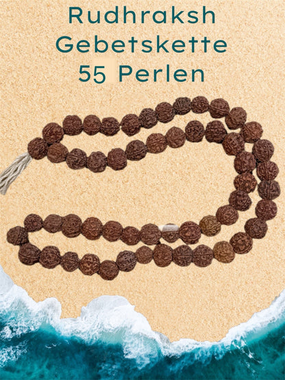 Große Rudraksha-Gebetsperle mit 58 Perlen auf einer Broschüre mit Vogelperspektive auf Rudhraksha an einem Meeresstrand