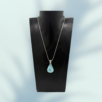 Larimar Anhänger mit einer Silber-Kette auf einen Schmuckstand mit blaufarbenem Hintergrund