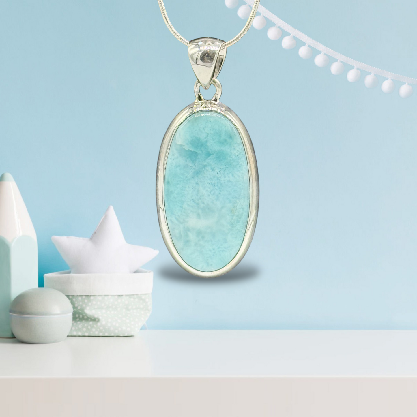 Zeigt Larimar Silber Anhänger mit einer Silber-Kette. Türkisblaues Hintergrund