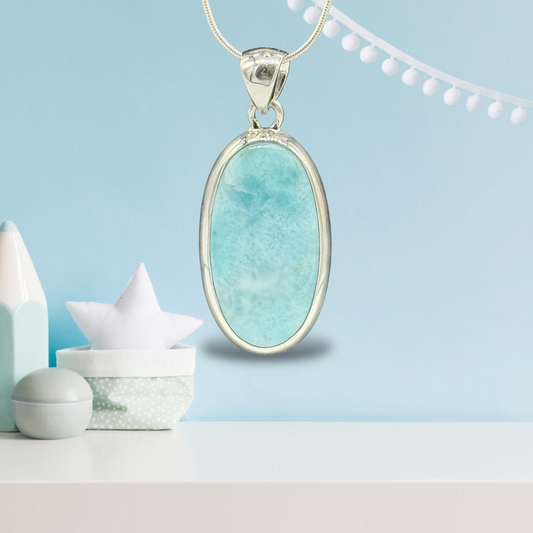 Zeigt Larimar Silber Anhänger mit einer Silber-Kette. Türkisblaues Hintergrund