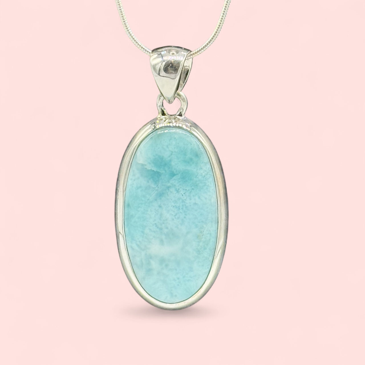 Zeigt Larimar Silber Anhänger mit einer Silber-Kette. Rosa Hintergrund