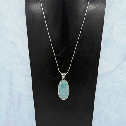 Zeigt Larimar Silber Anhänger mit einer Silber-Kette auf einen Schumckständer