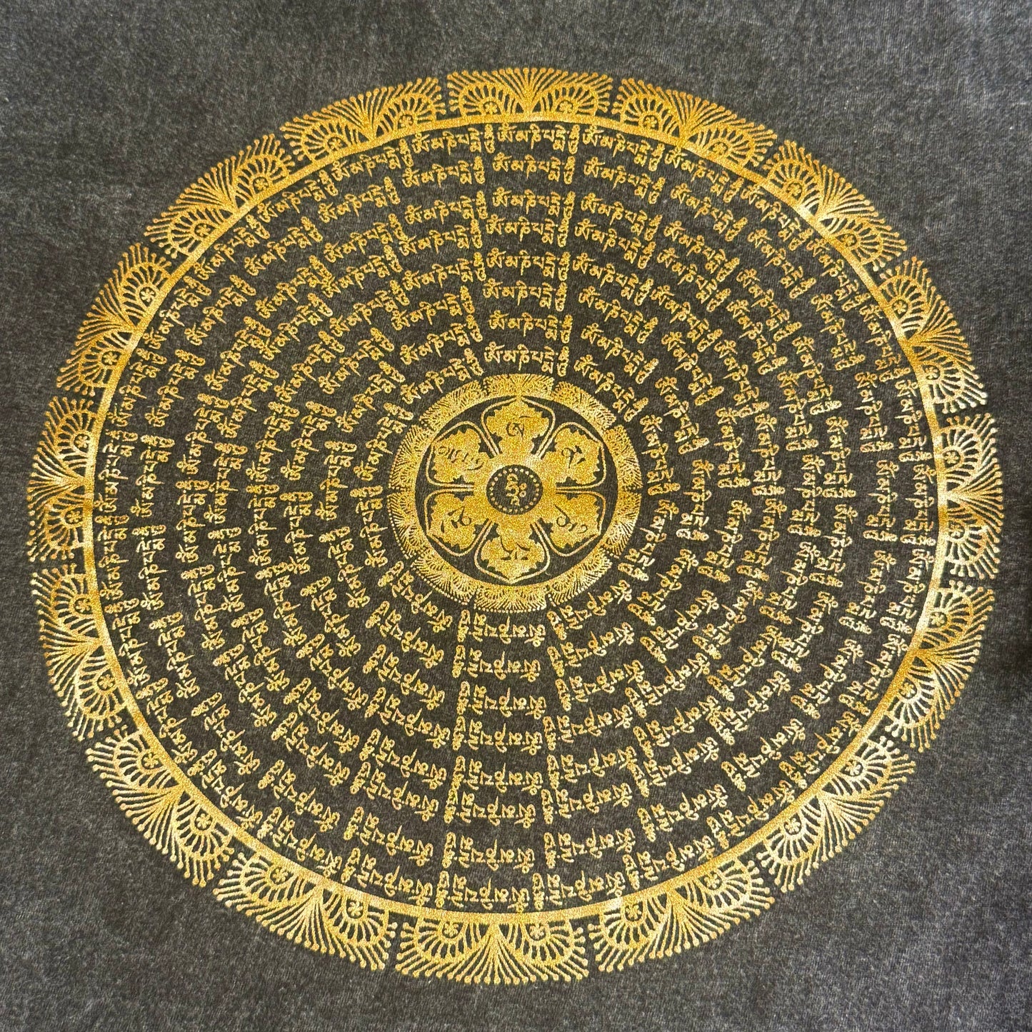 Zeigt ein schwarzes T-Shirt mit Mandala aus Om Mani Padme Hum Mantra