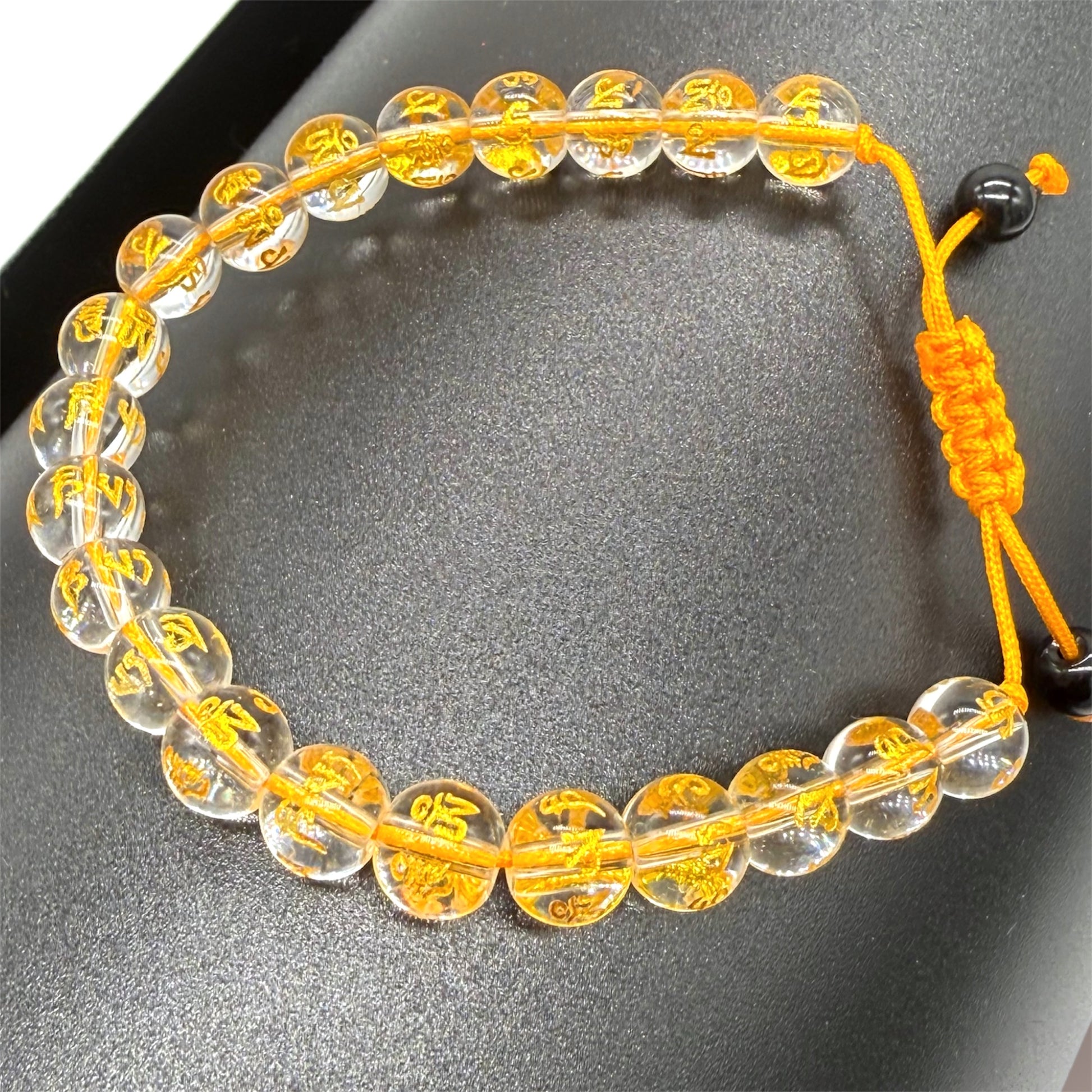 Goldenes Kristallarmband auf schwarzem Papierrollenhintergrund