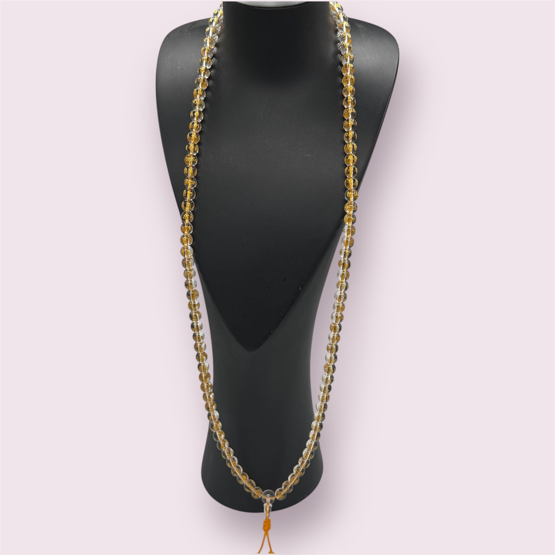 Goldenes Kristall Mala auf einem schwarzen Schmuckständer