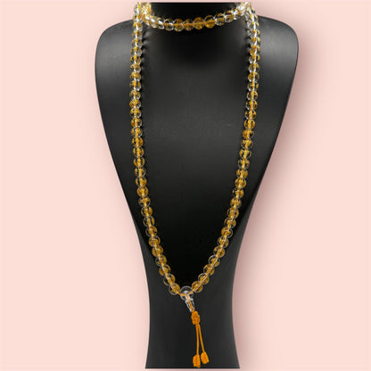 Goldenes Kristall Mala auf einem schwarzen Schmuckständer