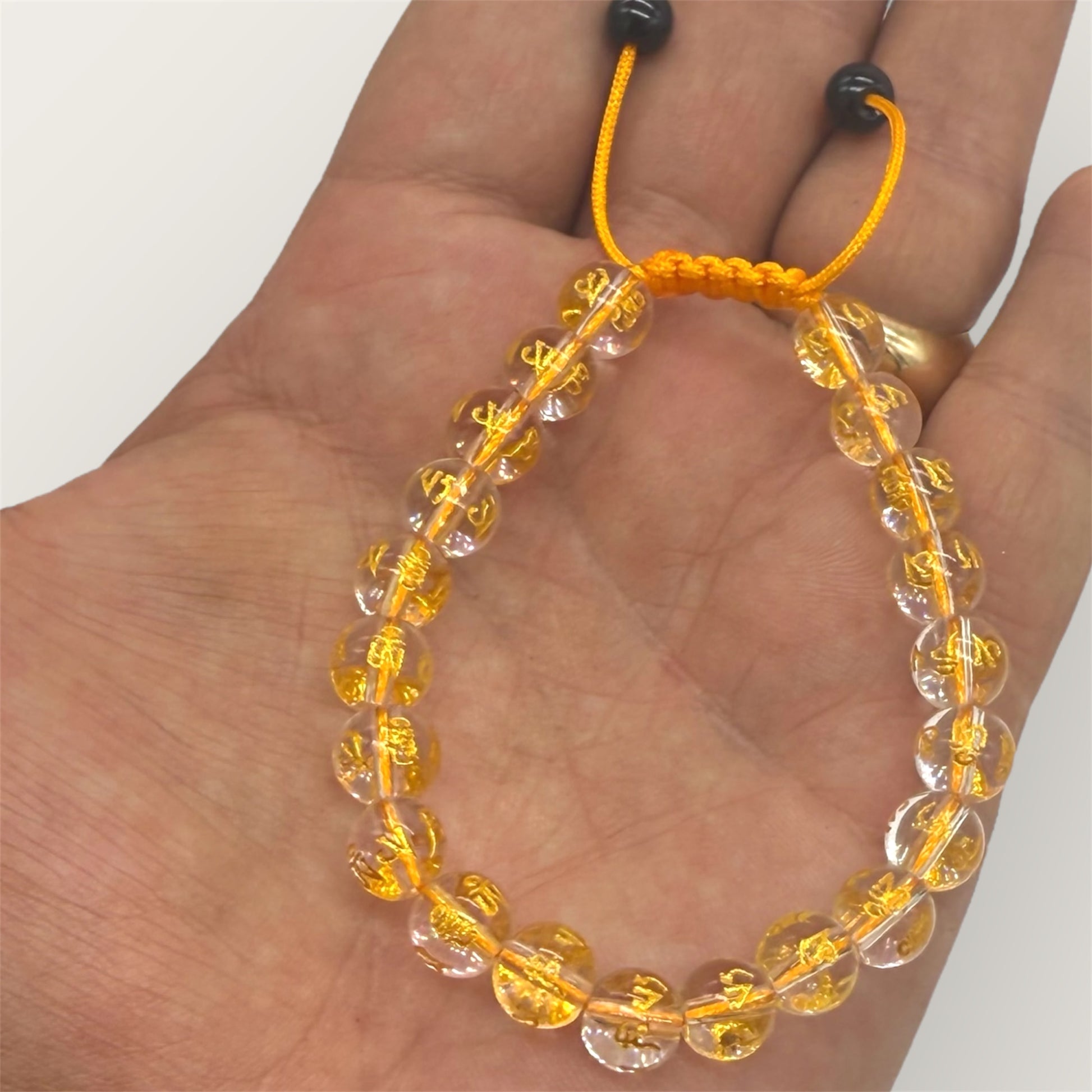 zeigt einen Kristallarmband auf einer Handfläche mit weißem Hintergrund