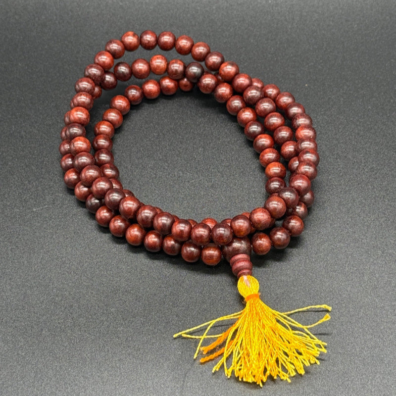 Gebetskette aus Rosenholz auf einem schwarzem Hintergrund