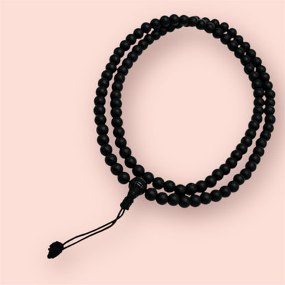 Shaligram 108 Mala, Schwarz auf einem beigen Hintergrund