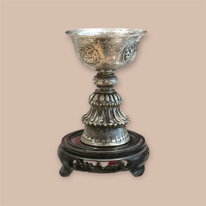 Eine antike Butterlampe aus Silber auf einem Sockel