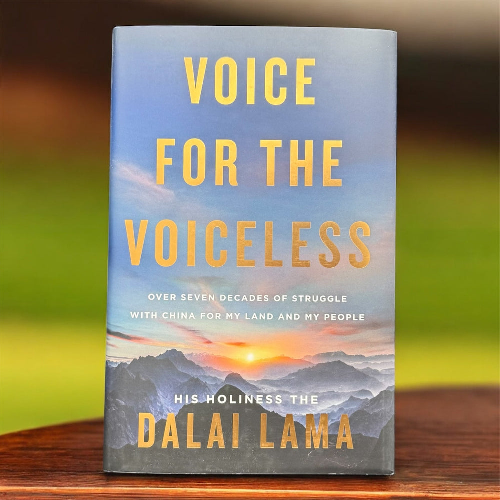 The photo shows a books called the Voice for the Voiceless on a wooden table top and  with a green background.