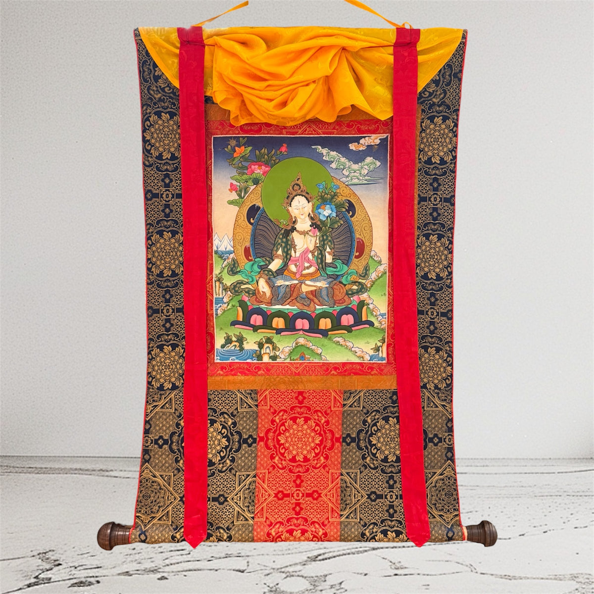 Weisse Tara Thangka mit dunkler goldfarben gemusterter Stoffeinfassung, roten Bändern und gelbem Überwurf, Gesamtansicht