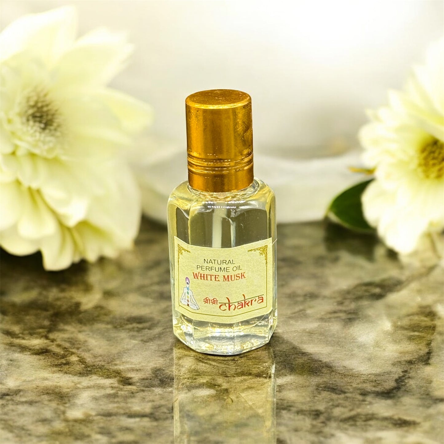 Zeigt Ölparfum aus weisser Moschus auf einer Marmorplatte  und im Hintergrund sind weisse Blumen