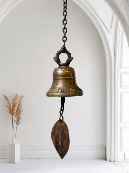 Windspiele in Glockenform aus Messing hängen in der Luft mit weißem Hintergrund