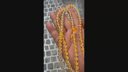 Halten und Zeigen einer Kristall-Mala in der Hand bei Tageslicht.